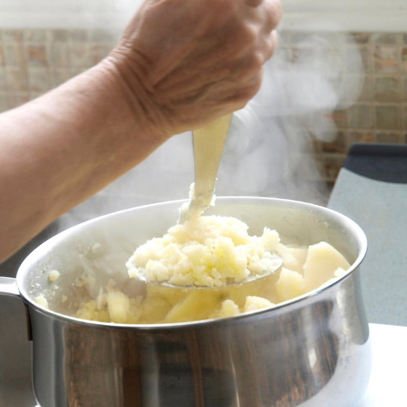 Zomers vispannetje met verse vis, seizoensgroenten en homemade aardappelpuree met pesto